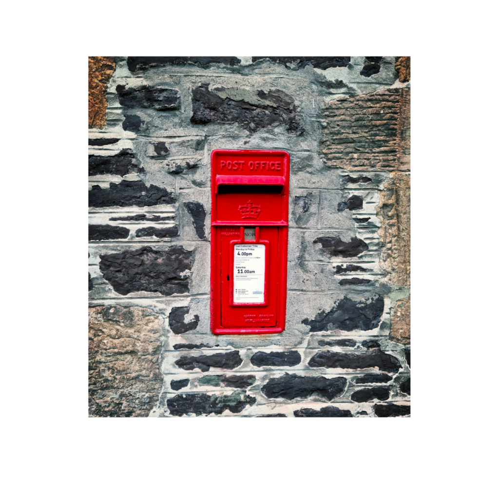 Roter Briefkasten an einer Steinmauer