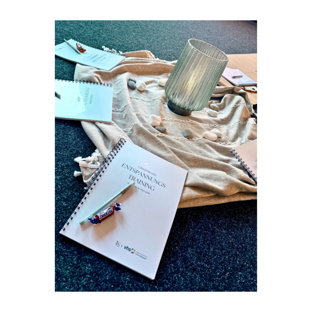 Materialien für Entspannungstraining mit Workbook, Kerze und Decke in ruhiger Atmosphäre